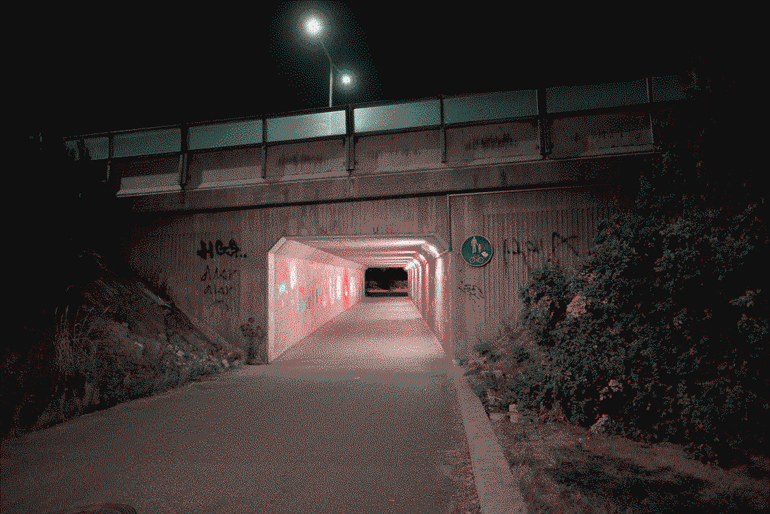 A tunnel covered in art in night time
